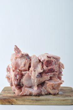 frozen raw chicken meat on board chopped with white background