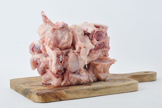 frozen raw chicken meat on board chopped with white background