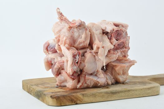 frozen raw chicken meat on board chopped with white background