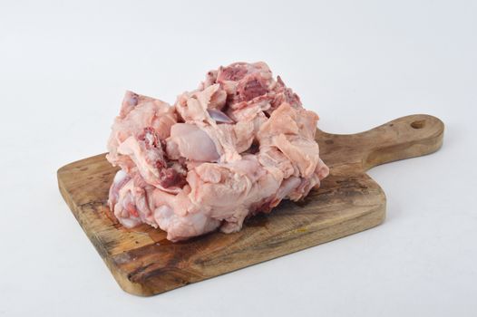 frozen raw chicken meat on board chopped with white background