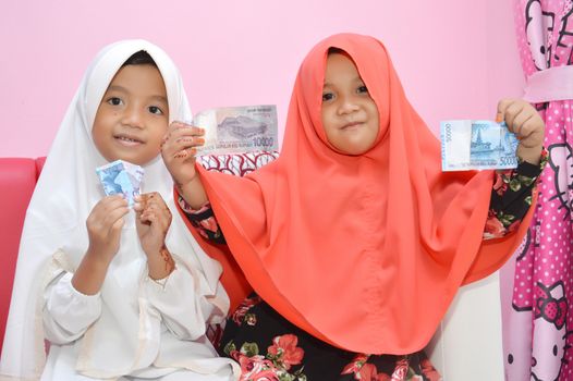 two Asian little girl Muslim showing results giving money visiting at Eid