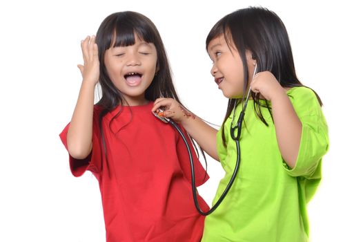 two asian little girl playing with a stethoscope