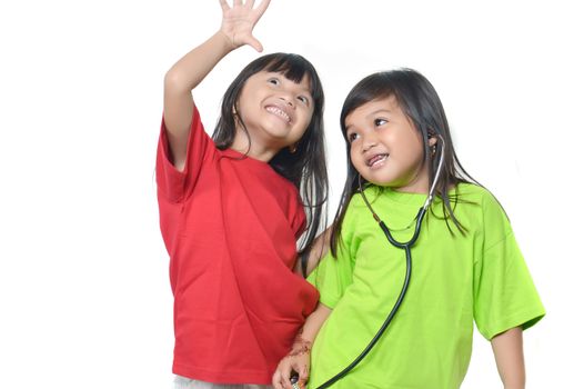 two asian little girl playing with a stethoscope