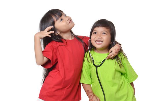 two asian little girl playing with a stethoscope