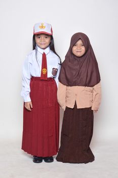 two asian little girl with primary school uniform and girl scout uniform