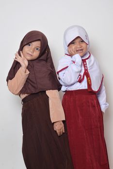 two asian little girl with primary school uniform and girl scout uniform