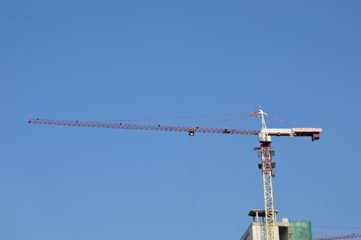 crane on a building in construction over blue sky