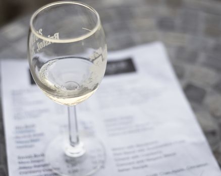 Vintage tone top view a glass of sweet white wine and tasting menu with price at local winery in North Texas, America