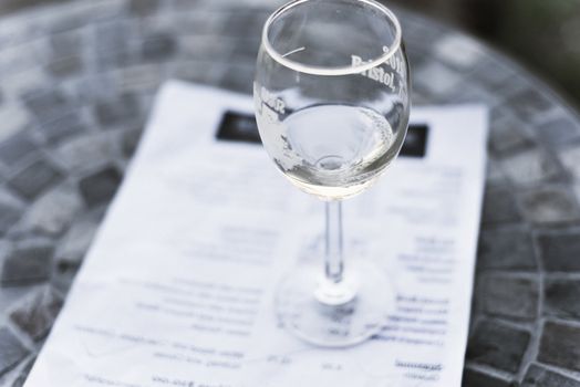 Vintage tone top view a glass of sweet white wine and tasting menu with price at local winery in North Texas, America