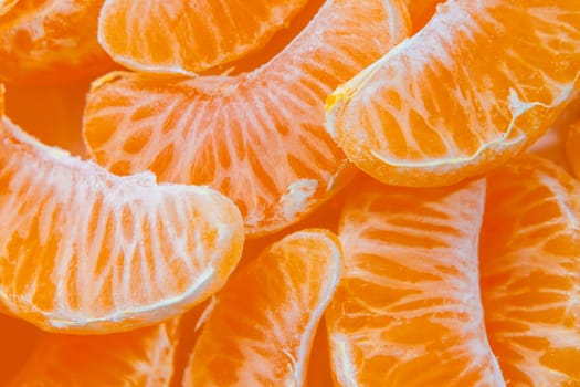 Several peeled ripe Mandarin slices, texture background.