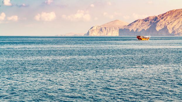 Sea, pleasure boats, rocky shores in the fjords of the Gulf of Oman.