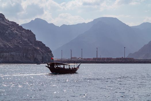 Sea, pleasure boats, rocky shores in the fjords of the Gulf of Oman.