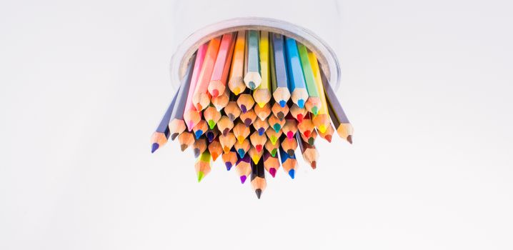 colorful pencils in a vase on a white background