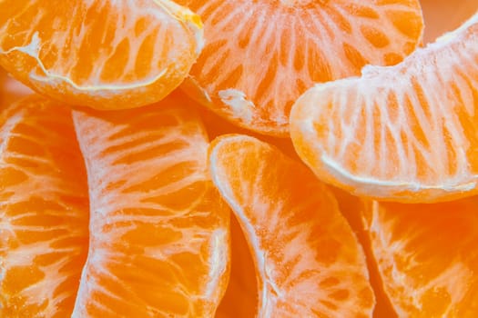 Several peeled ripe Mandarin slices, texture background.