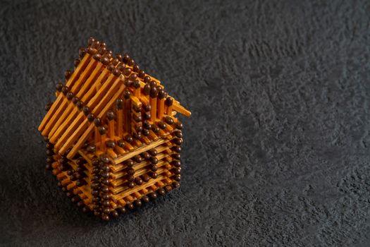 Little house model of matches on a dark background.