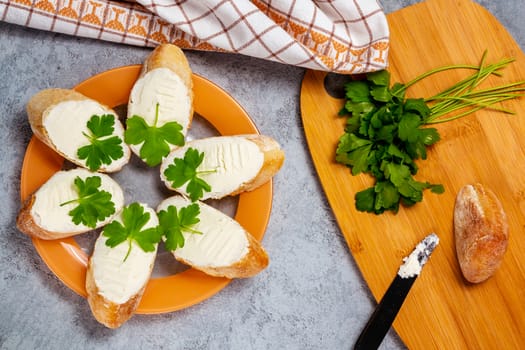 Freshly made Sandwiches with cream cheese on a plate on a gray table, top view.