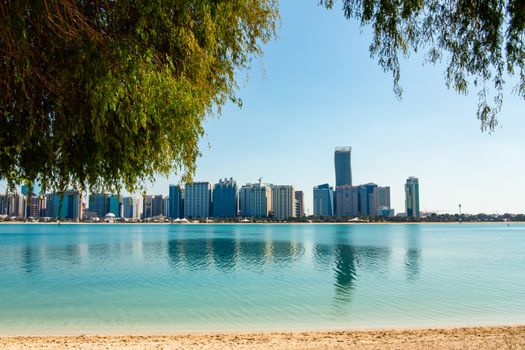 View of modern buildings from the canal shore in Abu Dhabi.