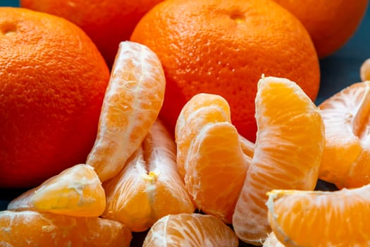 few peeled tangerine slices on the turquoise surface of the table, space for text.