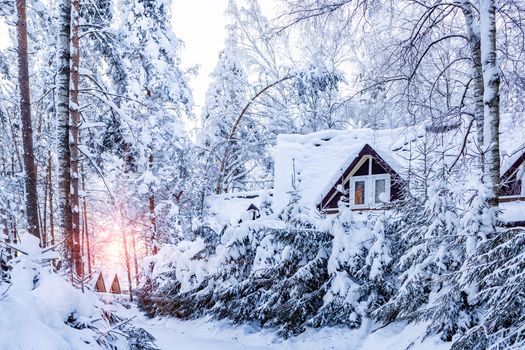 Cottages in the winter snow-covered forest at a ski resort.