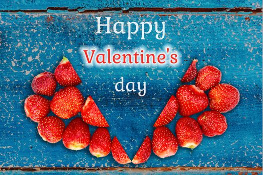 Beautiful card with a greeting on Valentine's Day - heart strawberries on turquoise background textures and the words Happy Valentine's Day.