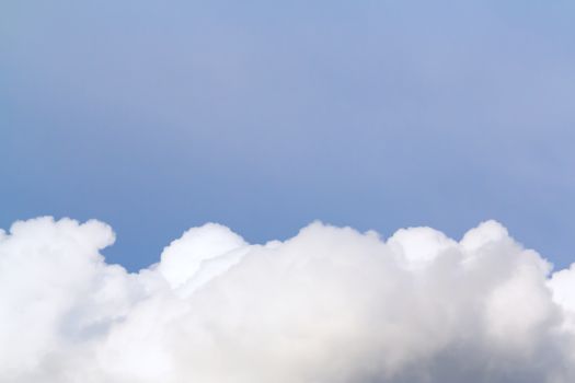 Lush cumulus clouds wide band in the summer blue sky. Background with copy space.