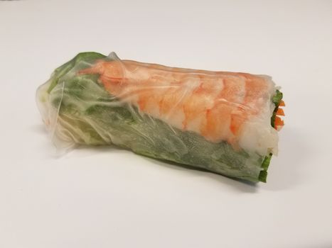 shrimp and lettuce and carrot rice paper roll on white desk or table