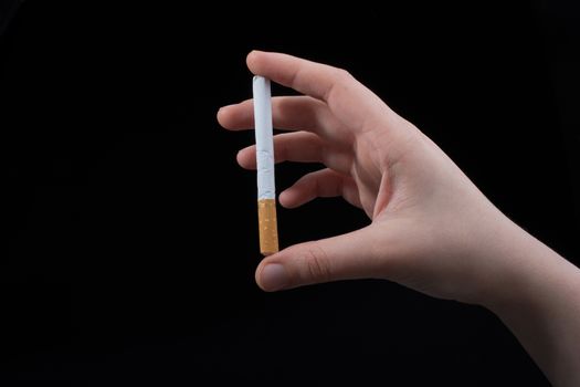 Hand is holding cigarette on a black background
