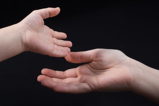 Hand is giving out cigarette on a black background