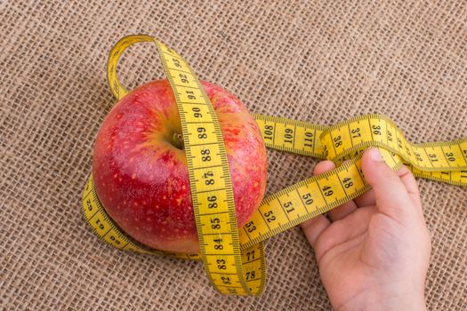 Health and diet concept with apple with a measurement  tape