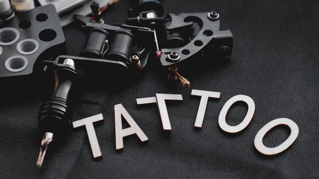Tattoo accessories With the inscription tattoo of wooden letters on a black background.