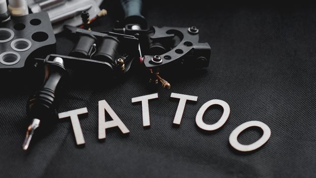 Tattoo accessories With the inscription tattoo of wooden letters on a black background.