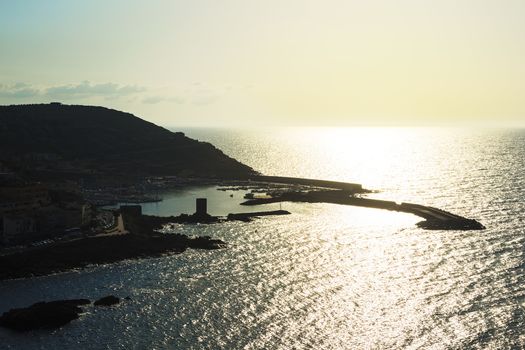 Aerial view of the silhouette of a harbor at sunset in Castelsardo, Sardinia, Italy