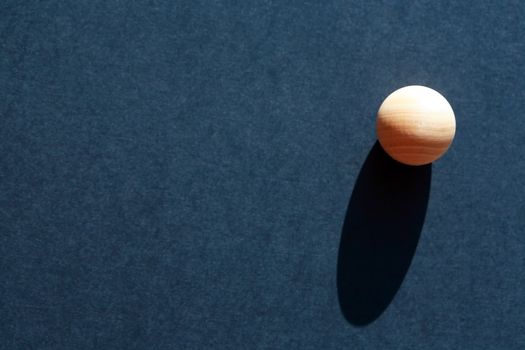 Abstract composition with three small wooden balls on dark blue background