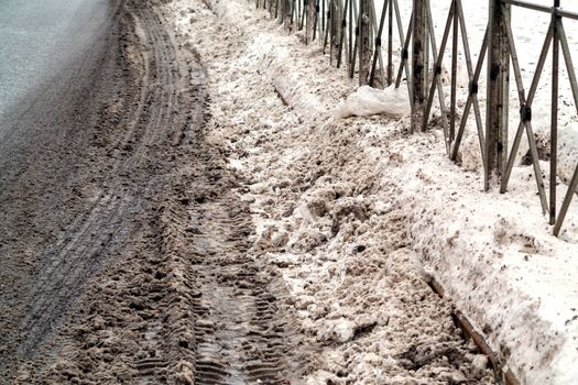 Dirty drifts after a snowfall on the side of the road.