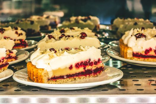 Pie with cranberries and cream laid out for sale in a cafe.