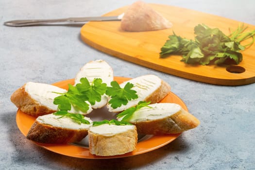 Freshly made Sandwiches with cream cheese on a plate on a gray table.