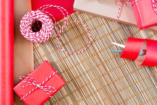 Preparing for the holiday - gift wrapping in red and beige wrapping paper.