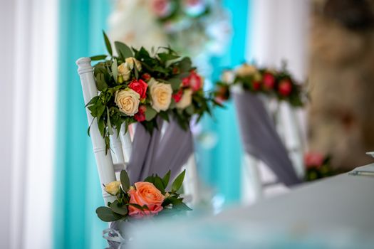 Decorated wedding chair with bouquet of roses. Bouquet of roses tied on chair in wedding party.