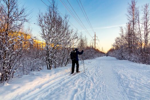 Male skier rides in the winter park at sunset.