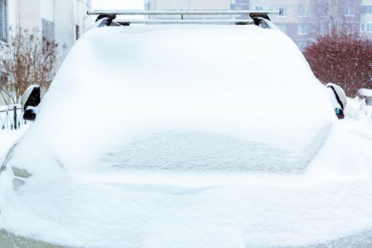 Snowfall, view of the snow-covered car in front.