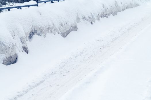 Winter road covered with snow, drifts on the side of the road.