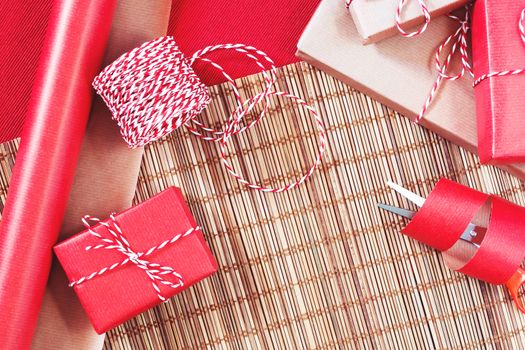 Preparing for the holiday - gift wrapping in red and beige wrapping paper.