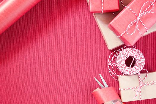 Preparing for the holiday - gift wrapping in red and beige wrapping paper.