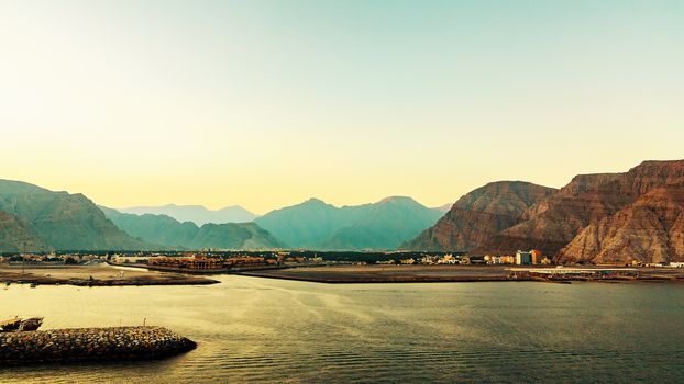 Sea coast of the Gulf of Oman, a small settlement or a town away on the shore.