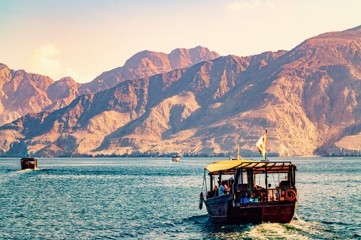 Sea, pleasure boats, rocky shores in the fjords of the Gulf of Oman.