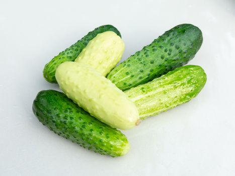 Cucumbers on the white surface of the table.