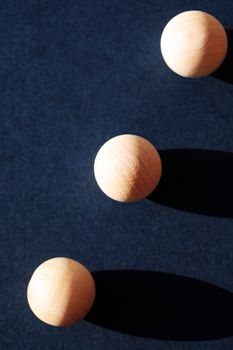 Abstract composition with three small wooden balls on dark blue background