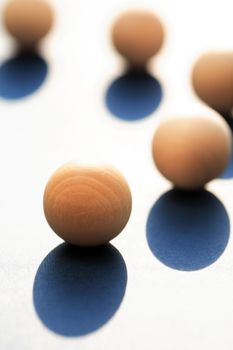 Abstract composition with few small wooden balls on light background