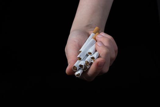 Hand is giving out cigarettes on a black background