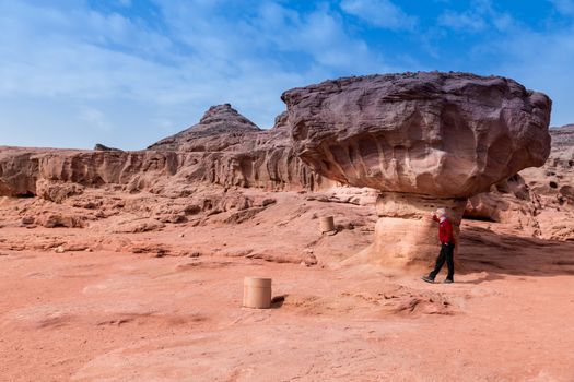 man at the famous mushroom rock in timna national park in israel, near eilat